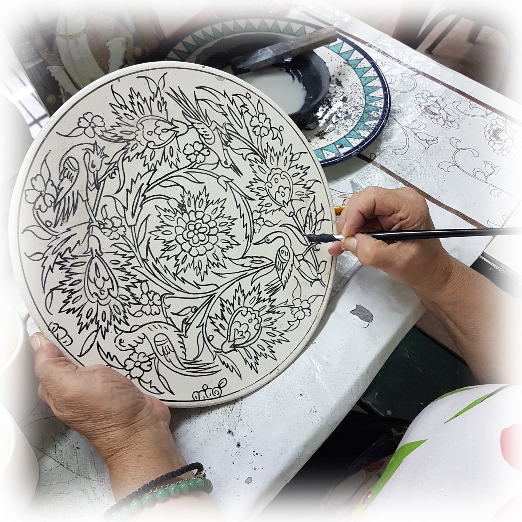 The painting of a decorative hand painted plate